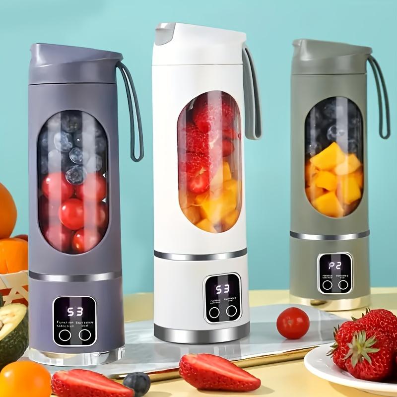 Three portable blenders with fruit inside on a light blue background